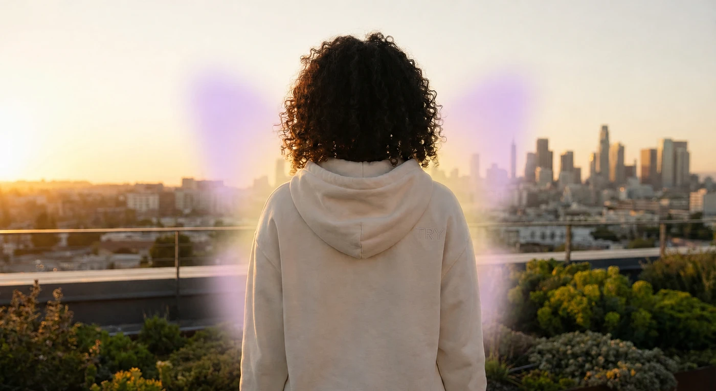 Woman in a TRY hoodie facing a city skyline